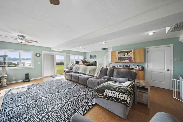 living room with ceiling fan, wood-type flooring, and a textured ceiling