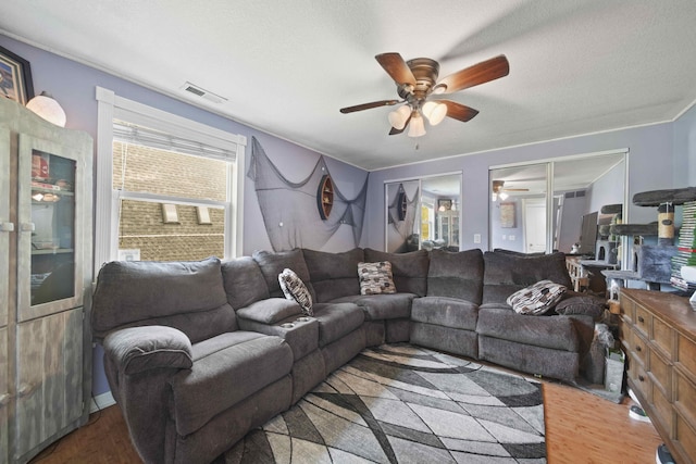 living room with wood-type flooring, a textured ceiling, and ceiling fan