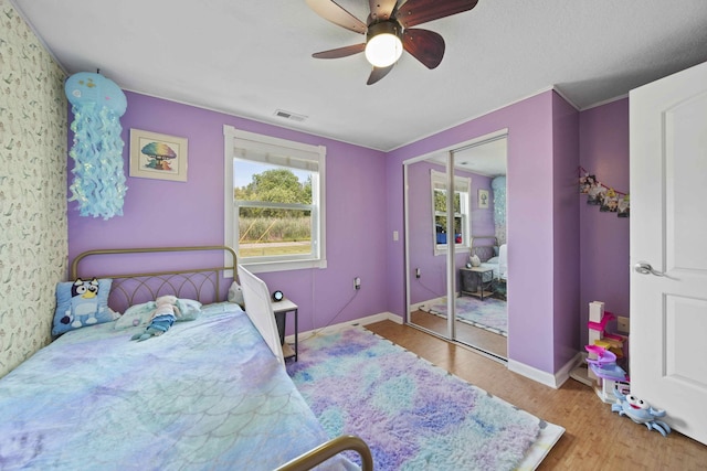 bedroom with hardwood / wood-style floors, ceiling fan, and a closet