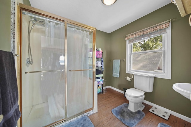 bathroom with toilet, hardwood / wood-style floors, and walk in shower