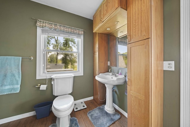 bathroom featuring a healthy amount of sunlight, wood-type flooring, and toilet