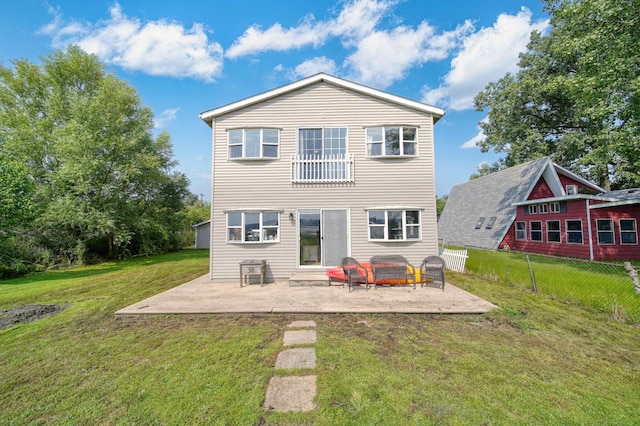 back of house with a lawn and a patio area