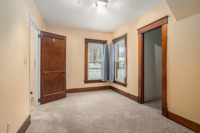 carpeted spare room with a textured ceiling