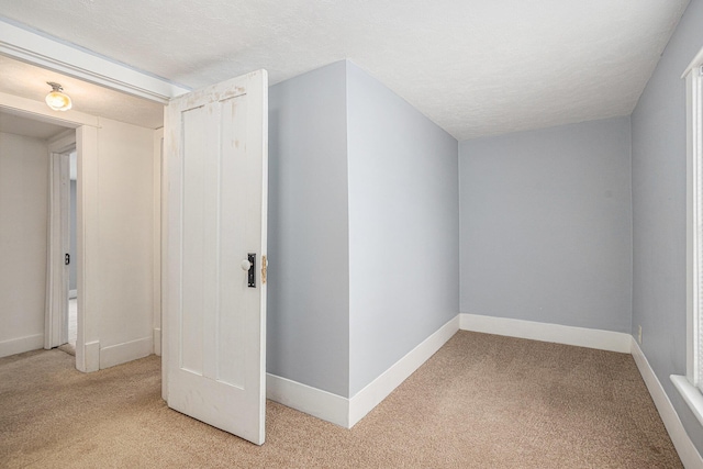 additional living space featuring light carpet and a textured ceiling