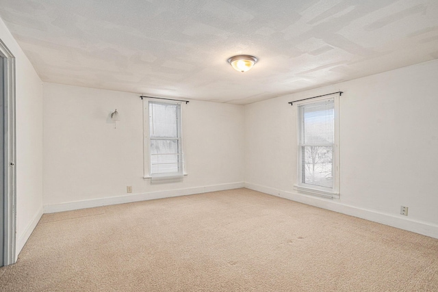 carpeted empty room featuring a textured ceiling