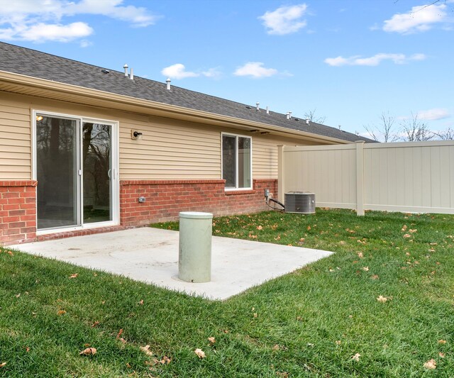 back of property with a patio area, a yard, and central AC