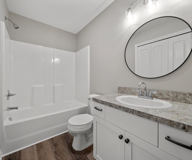 full bathroom featuring hardwood / wood-style floors, vanity, toilet, and shower / bathtub combination