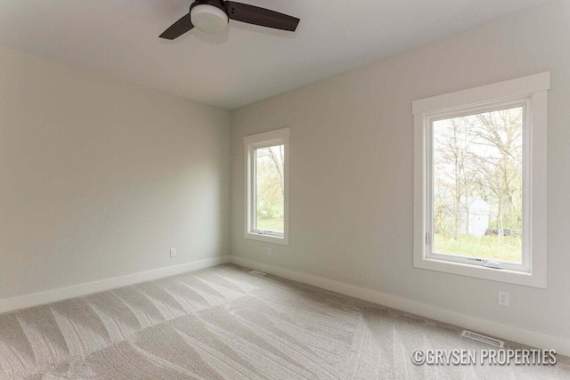 carpeted spare room with ceiling fan