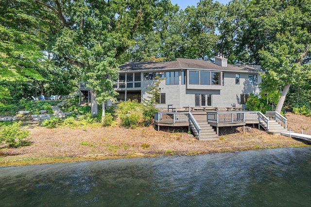 back of property featuring a deck with water view