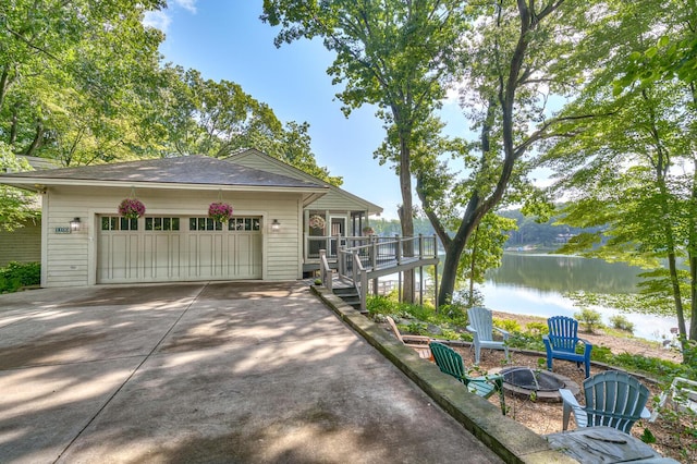 exterior space featuring a deck with water view and an outdoor fire pit