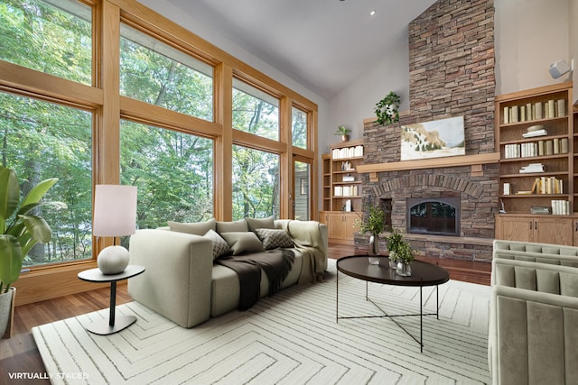 living room with hardwood / wood-style flooring, a fireplace, and high vaulted ceiling