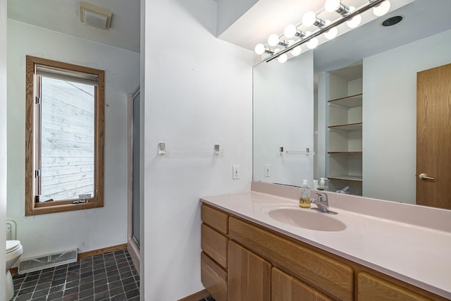 bathroom with tile patterned floors, vanity, toilet, and an enclosed shower