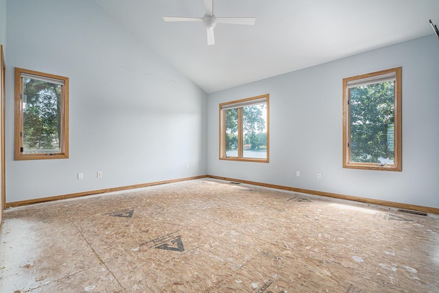 empty room featuring ceiling fan, plenty of natural light, and vaulted ceiling