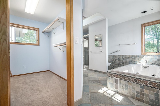 bathroom featuring plus walk in shower and a wealth of natural light