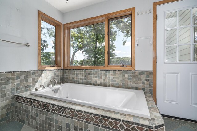 bathroom with tile patterned floors and tiled tub