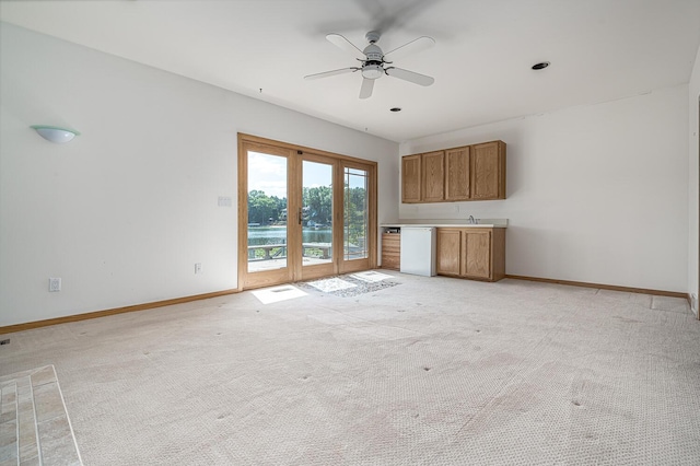 unfurnished living room with ceiling fan and light carpet