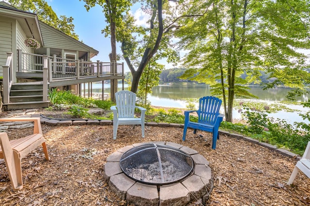 view of yard with a deck with water view and an outdoor fire pit