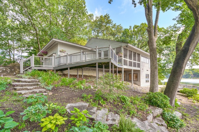 back of property with a wooden deck and a sunroom