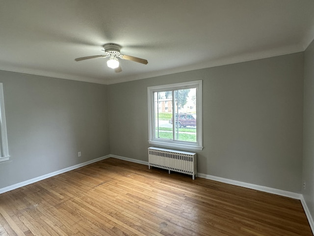 spare room featuring light hardwood / wood-style floors, ornamental molding, and radiator