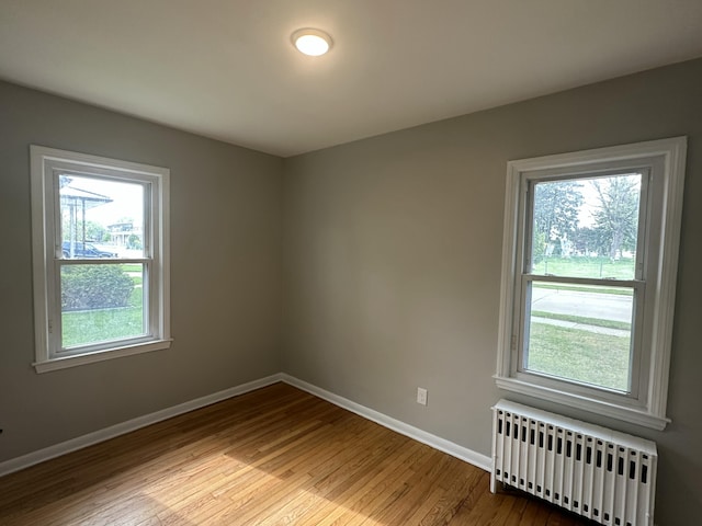 unfurnished room with light wood-type flooring and radiator