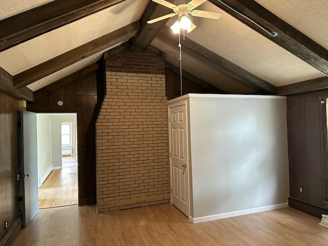 additional living space featuring vaulted ceiling with beams, light hardwood / wood-style floors, ceiling fan, and a baseboard heating unit