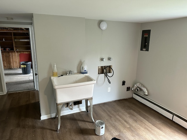 laundry room with hardwood / wood-style floors, electric panel, and a baseboard heating unit