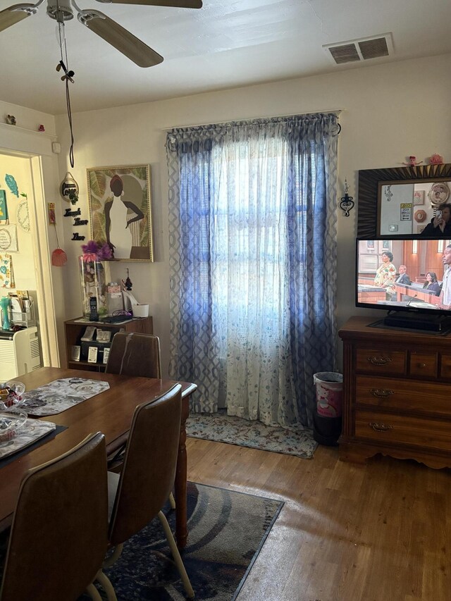 dining area with hardwood / wood-style floors and ceiling fan