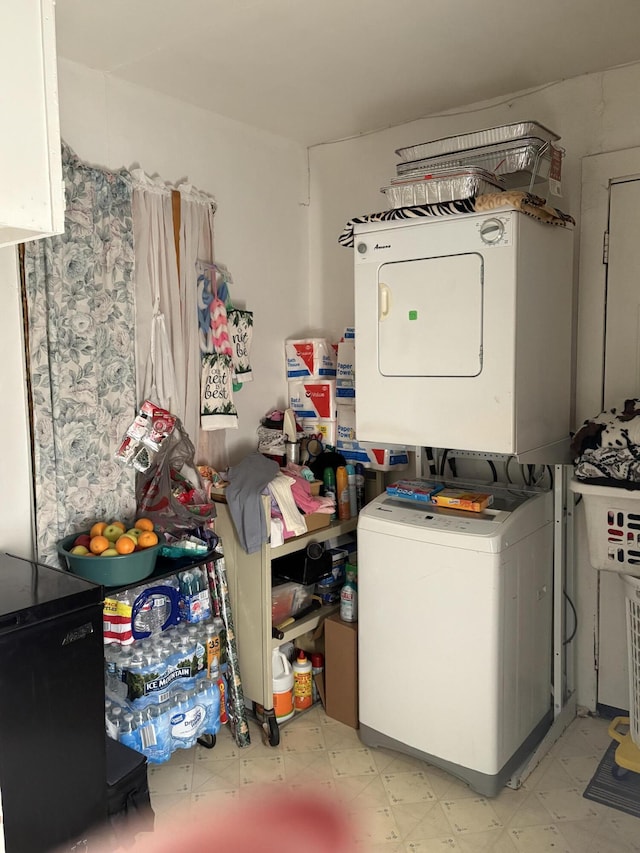 clothes washing area featuring stacked washer and clothes dryer