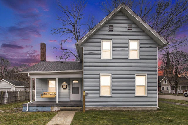 view of front facade featuring covered porch and a yard