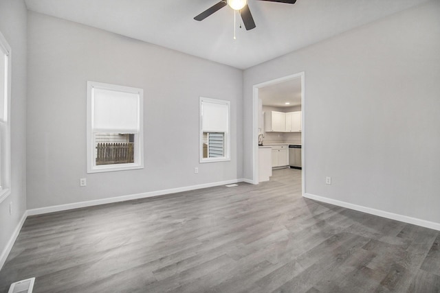 spare room with ceiling fan and light wood-type flooring