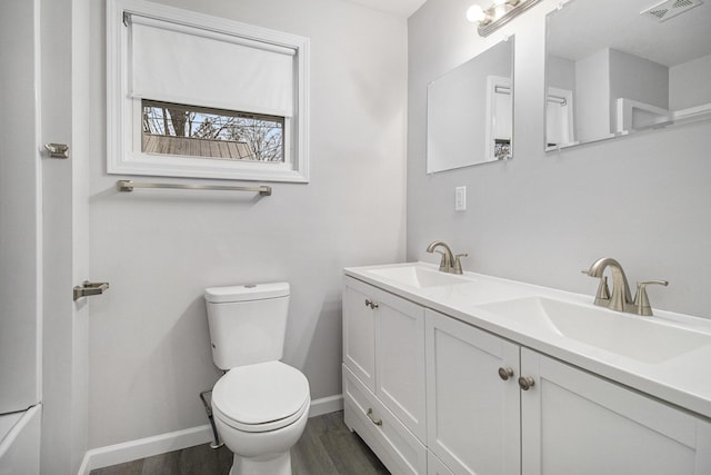 bathroom with hardwood / wood-style floors, vanity, and toilet