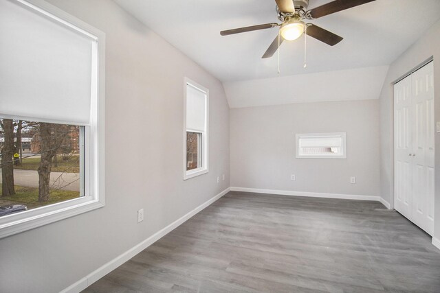 unfurnished bedroom with ceiling fan, wood-type flooring, and lofted ceiling