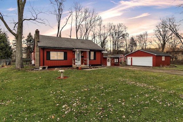 view of front of house with an outbuilding, a garage, and a lawn