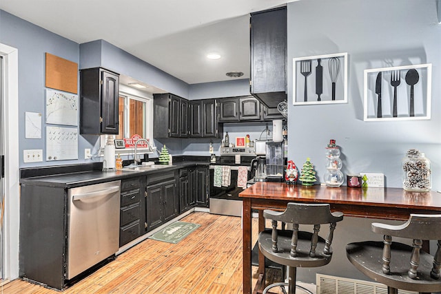 kitchen with sink, stainless steel appliances, and light hardwood / wood-style flooring