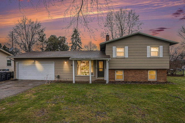 tri-level home with a yard and a garage