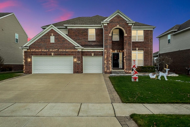 view of property with a garage and a lawn