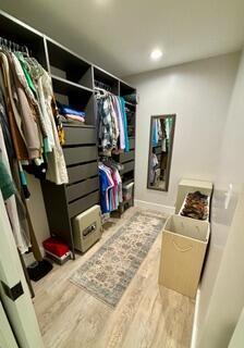 spacious closet with hardwood / wood-style flooring