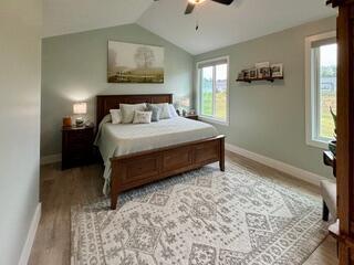 bedroom featuring ceiling fan, lofted ceiling, and light hardwood / wood-style flooring