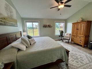 bedroom featuring multiple windows, ceiling fan, and lofted ceiling