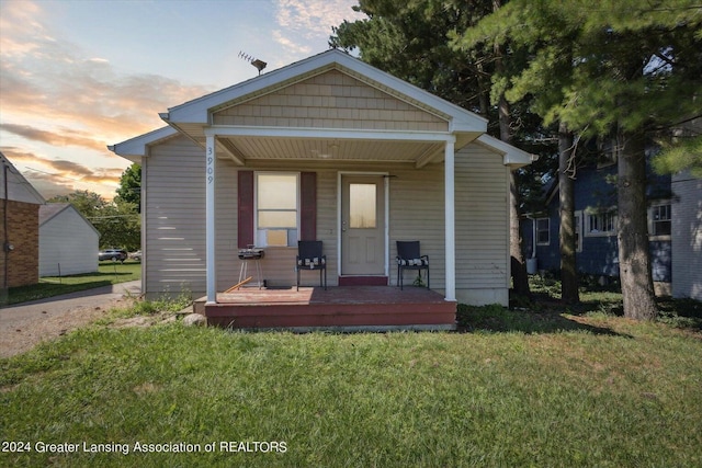 view of front of house featuring a lawn and covered porch