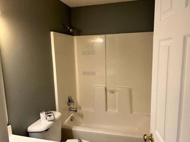 bathroom featuring toilet and washtub / shower combination