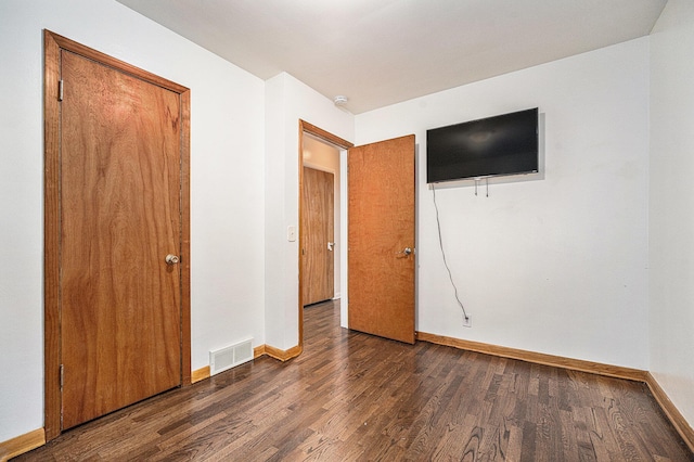 unfurnished bedroom with dark hardwood / wood-style floors