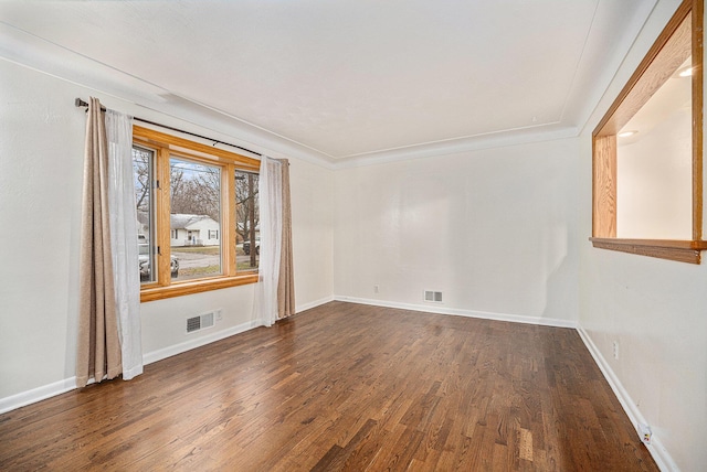 unfurnished room featuring crown molding and dark wood-type flooring