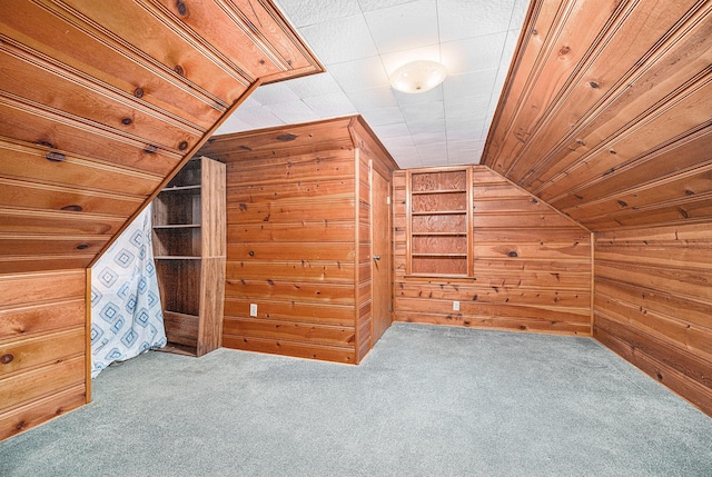 additional living space with lofted ceiling, wood walls, carpet floors, and built in features