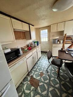 kitchen featuring white cabinets, refrigerator, and white dishwasher