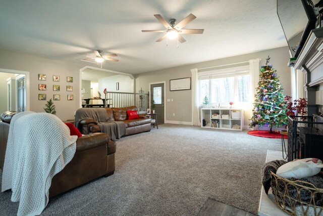 carpeted living room with ceiling fan