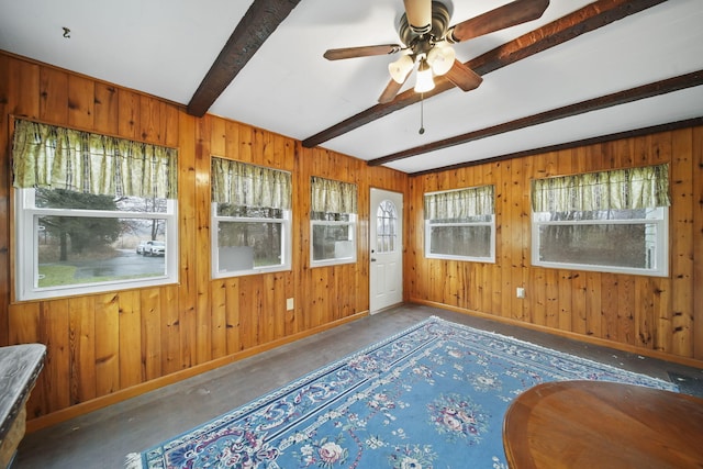 unfurnished sunroom with ceiling fan and beam ceiling