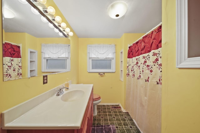 bathroom featuring vanity, toilet, and walk in shower