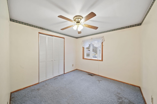 unfurnished bedroom featuring ceiling fan, a closet, carpet, and ornamental molding