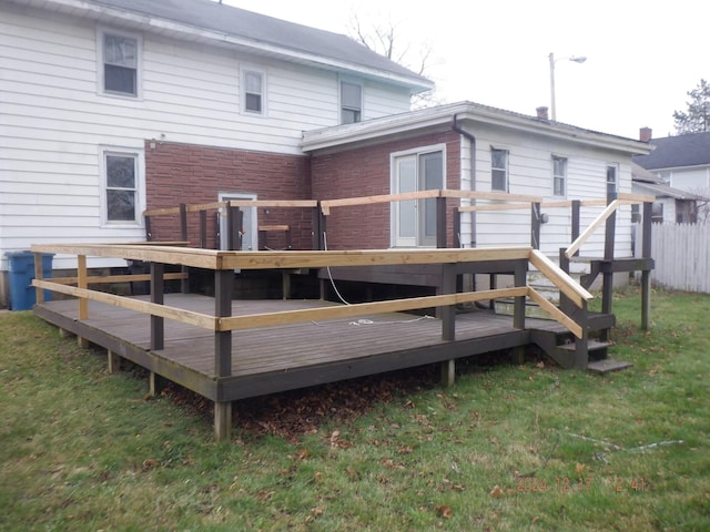 rear view of property featuring a yard and a wooden deck